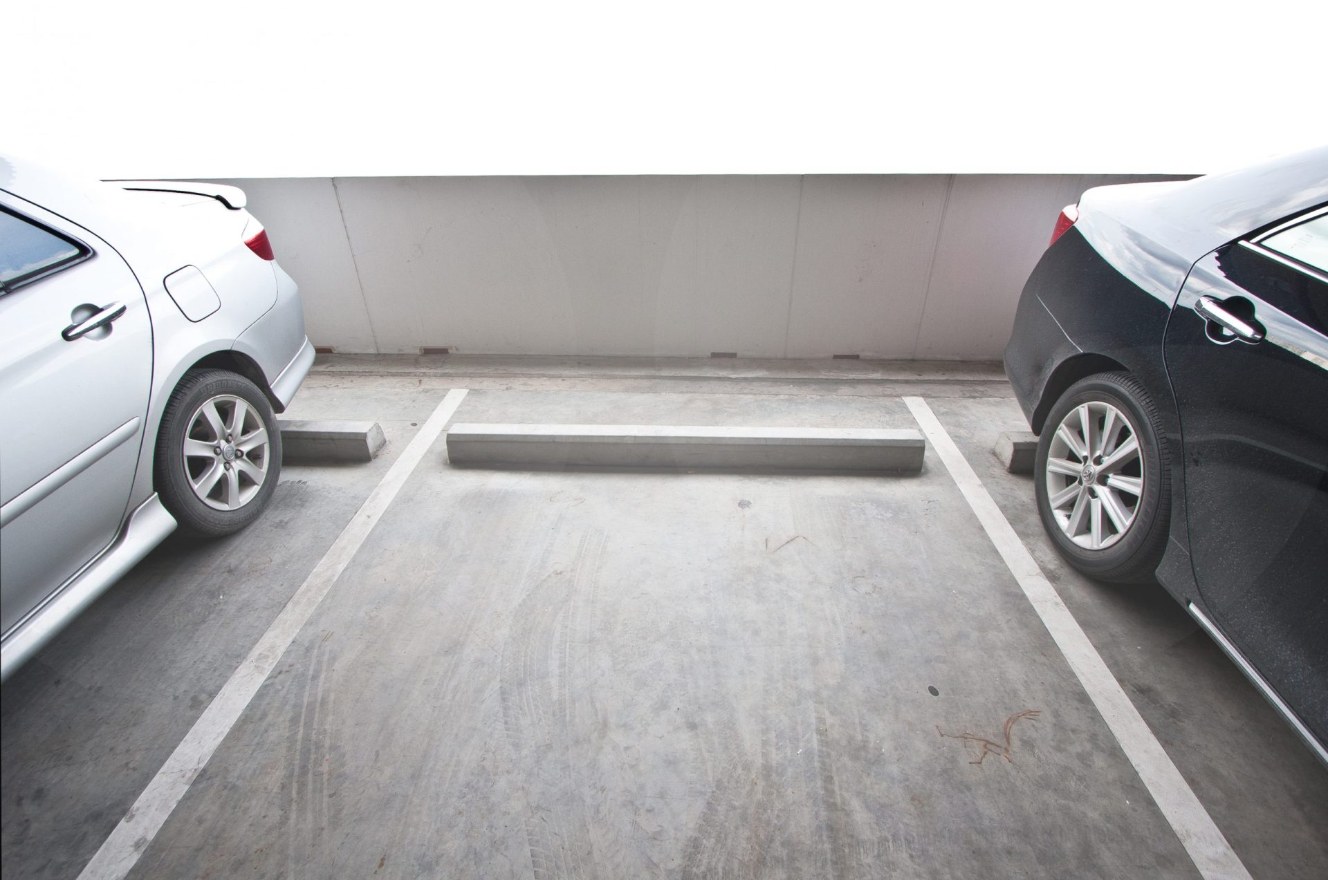 Empy parking space with two near cars